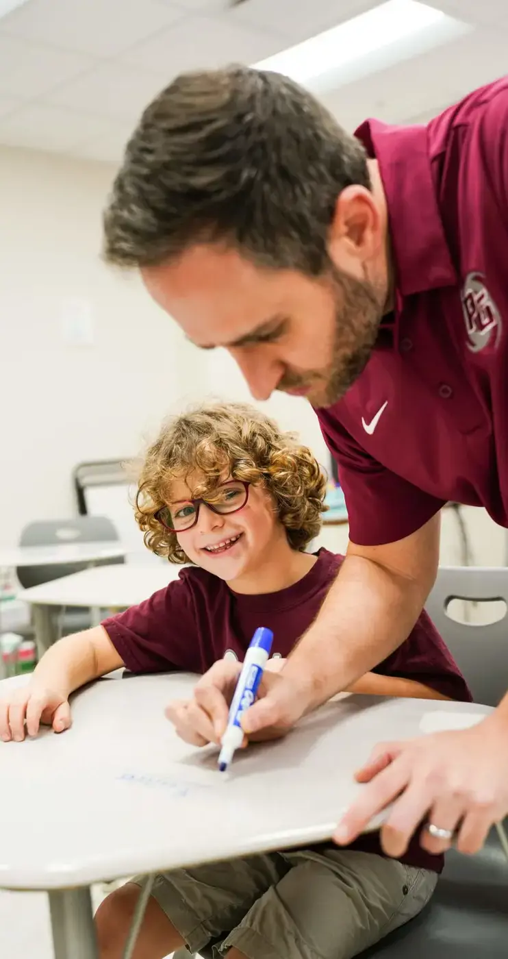 Porter-Gaud teacher helps a student in class